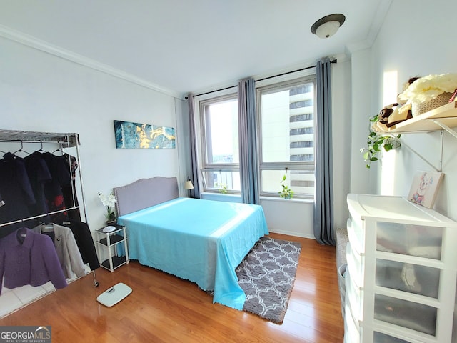 bedroom featuring hardwood / wood-style floors and ornamental molding