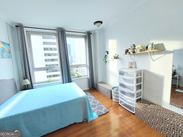 bedroom featuring hardwood / wood-style floors and ornamental molding