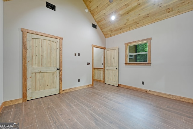 spare room featuring hardwood / wood-style floors, high vaulted ceiling, and wood ceiling