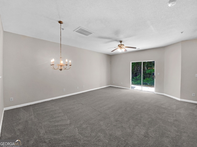 spare room featuring ceiling fan with notable chandelier, dark colored carpet, and a textured ceiling