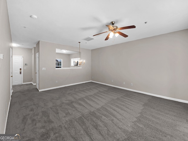 carpeted spare room featuring ceiling fan with notable chandelier