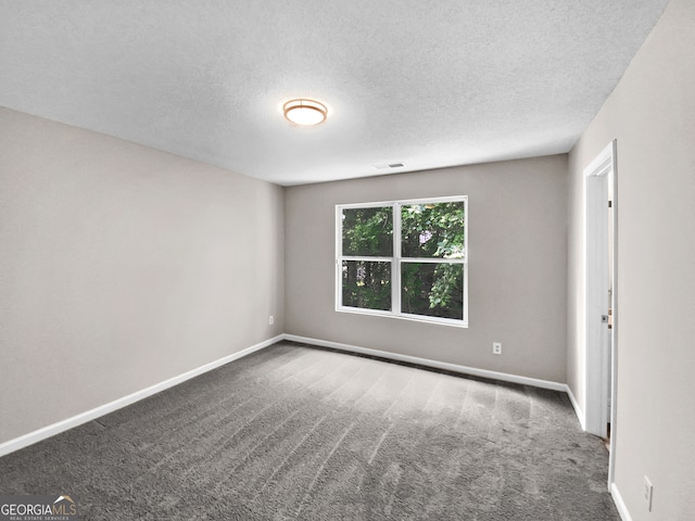 unfurnished room with carpet flooring and a textured ceiling