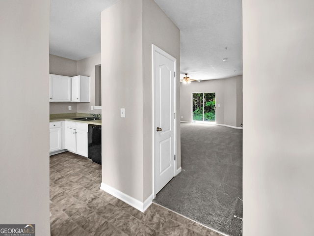 hallway with light colored carpet and sink