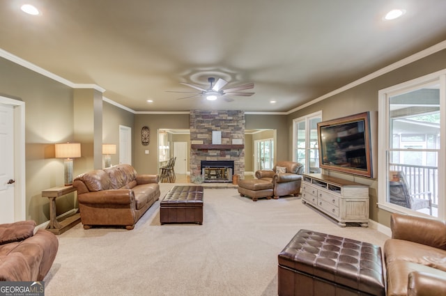 carpeted living room featuring a fireplace, a wealth of natural light, ceiling fan, and ornamental molding