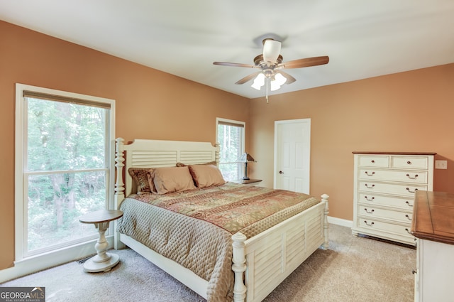 carpeted bedroom with multiple windows and ceiling fan