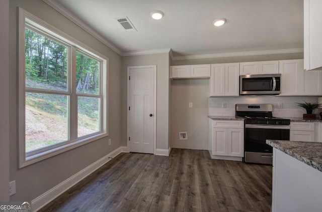 kitchen with dark hardwood / wood-style floors, light stone countertops, tasteful backsplash, white cabinets, and appliances with stainless steel finishes