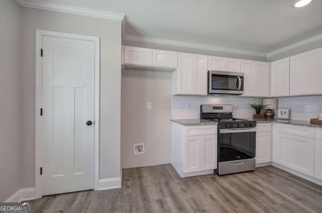 kitchen with stainless steel appliances, light wood-type flooring, and white cabinetry