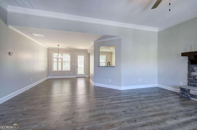 unfurnished living room with a stone fireplace, ceiling fan with notable chandelier, dark hardwood / wood-style floors, and crown molding