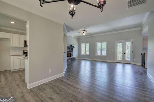 unfurnished living room featuring crown molding, ceiling fan, dark hardwood / wood-style flooring, and a fireplace