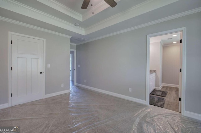 bedroom with a raised ceiling, ceiling fan, crown molding, and ensuite bathroom