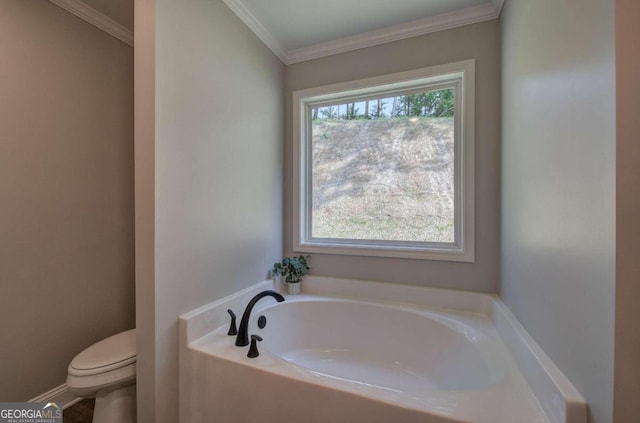 bathroom featuring ornamental molding, plenty of natural light, toilet, and a bathing tub