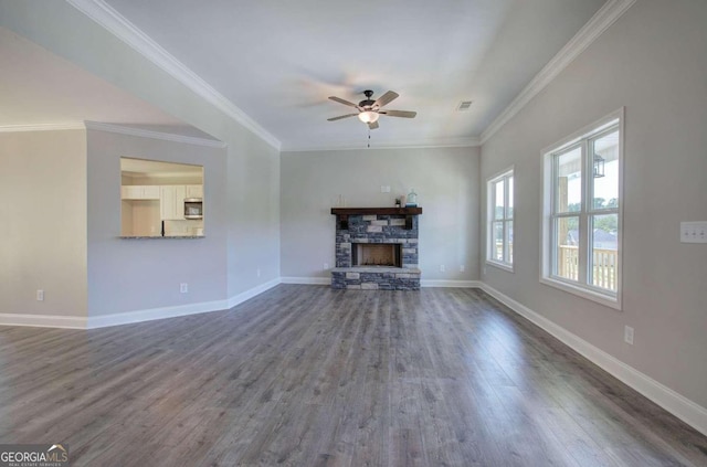 unfurnished living room featuring a stone fireplace, dark hardwood / wood-style flooring, and crown molding