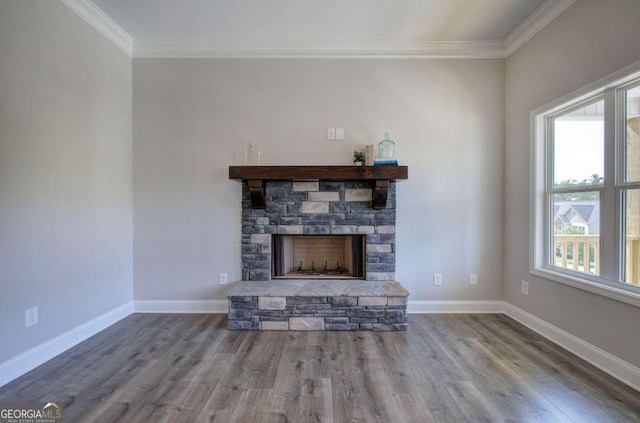 unfurnished living room featuring wood-type flooring, a stone fireplace, and ornamental molding