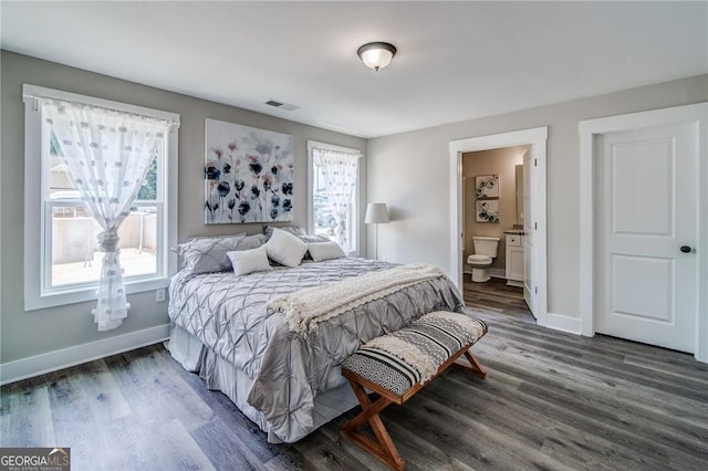 bedroom featuring connected bathroom and dark hardwood / wood-style floors