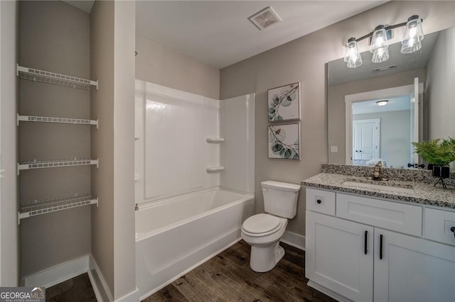 full bathroom with wood-type flooring, vanity, shower / bath combination, and toilet