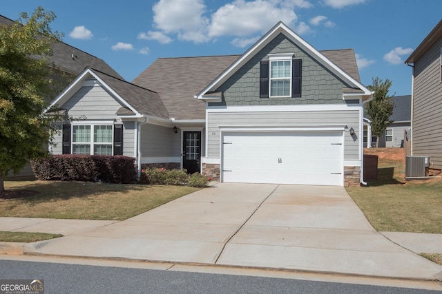 craftsman inspired home featuring a front lawn, a garage, and central air condition unit