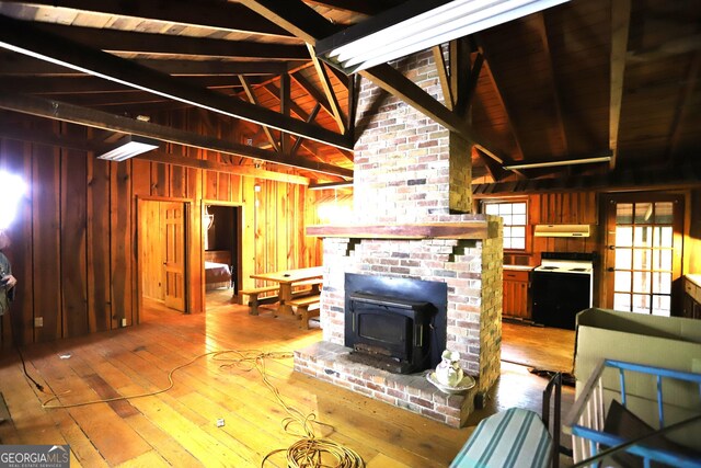 living room with lofted ceiling with beams, hardwood / wood-style floors, brick wall, and wooden walls