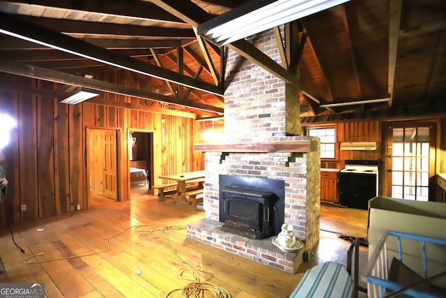 living room with lofted ceiling with beams, light hardwood / wood-style floors, brick wall, and wooden walls