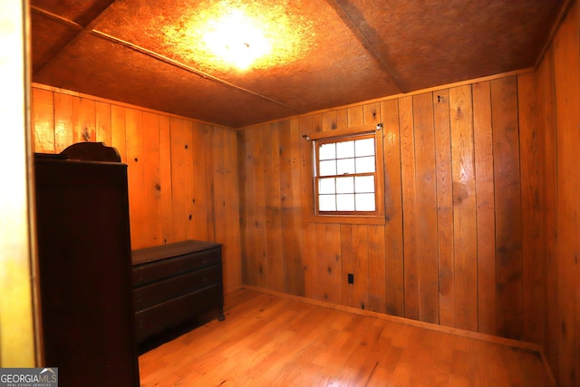 unfurnished bedroom with wood walls and light hardwood / wood-style floors