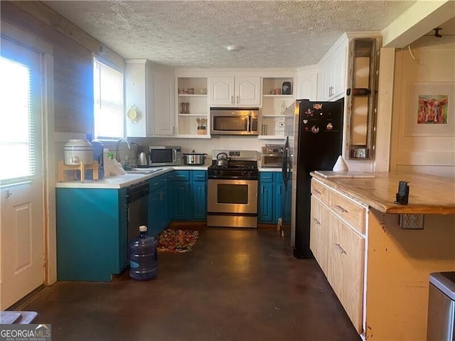 kitchen with white cabinets, plenty of natural light, blue cabinetry, and range