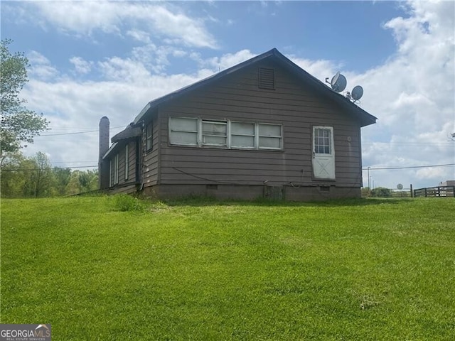 view of side of home with a lawn