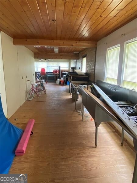 recreation room featuring hardwood / wood-style flooring, wood ceiling, and beam ceiling