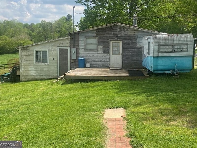 back of house with a deck and a lawn