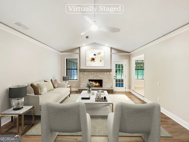 living room featuring wood-type flooring, ceiling fan, vaulted ceiling, and crown molding