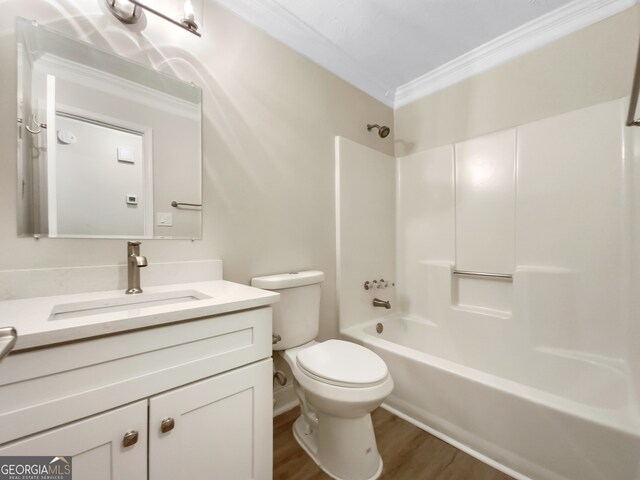 full bathroom with shower / washtub combination, crown molding, toilet, vanity, and hardwood / wood-style flooring