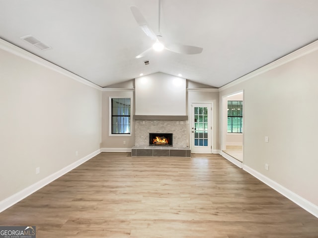 unfurnished living room featuring wood-type flooring, a fireplace, crown molding, vaulted ceiling, and ceiling fan