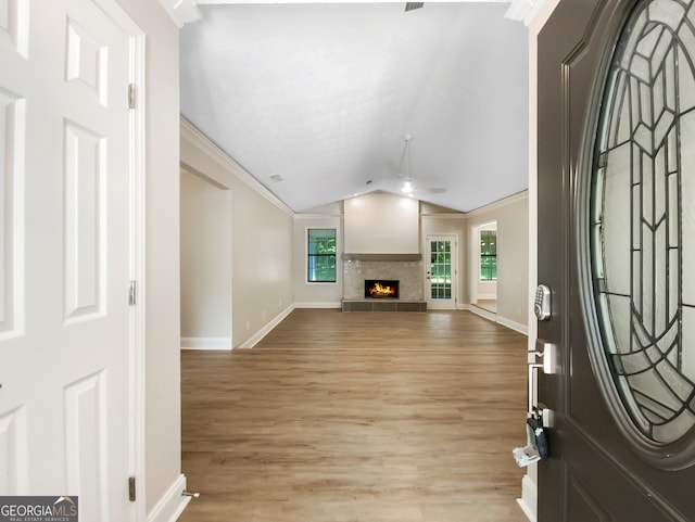 foyer entrance with lofted ceiling, light hardwood / wood-style floors, and crown molding