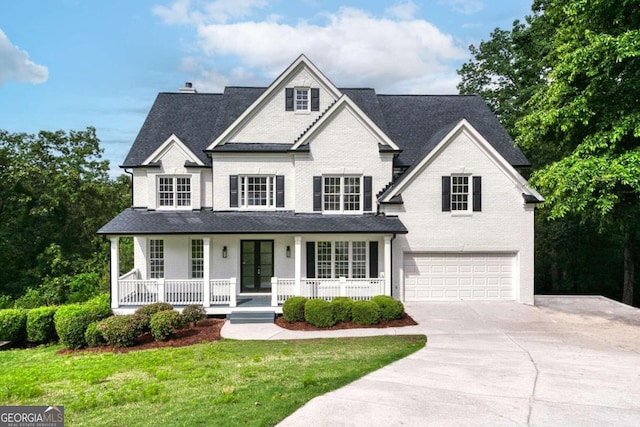 view of front of home featuring a garage, a porch, and a front lawn