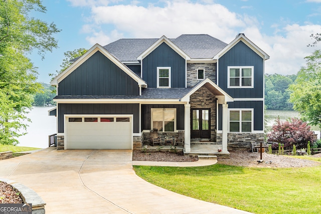 craftsman house with a front yard, a porch, and a garage