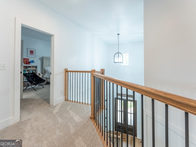 hall with light colored carpet and a wealth of natural light