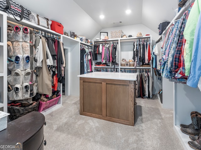 spacious closet with light colored carpet and vaulted ceiling