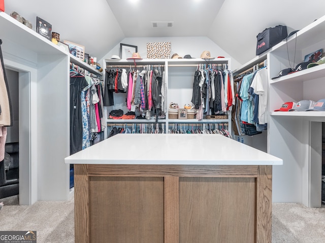 walk in closet with light colored carpet and lofted ceiling