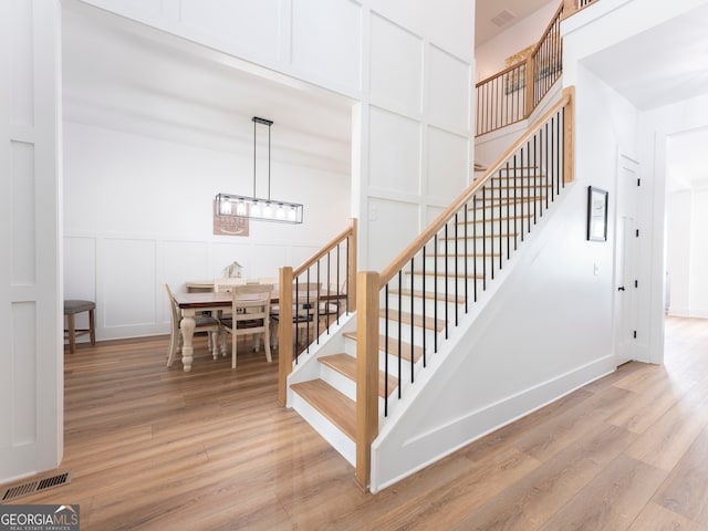 stairway featuring light hardwood / wood-style floors and a chandelier