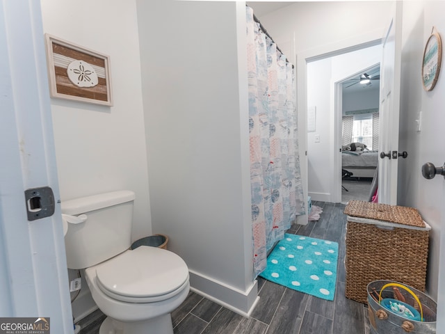 bathroom with wood-type flooring, ceiling fan, and toilet