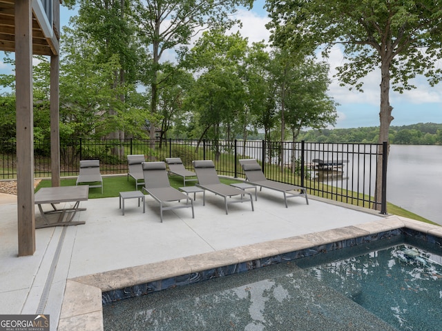 view of pool featuring a water view and a patio