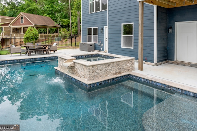 view of swimming pool featuring an in ground hot tub and a patio area