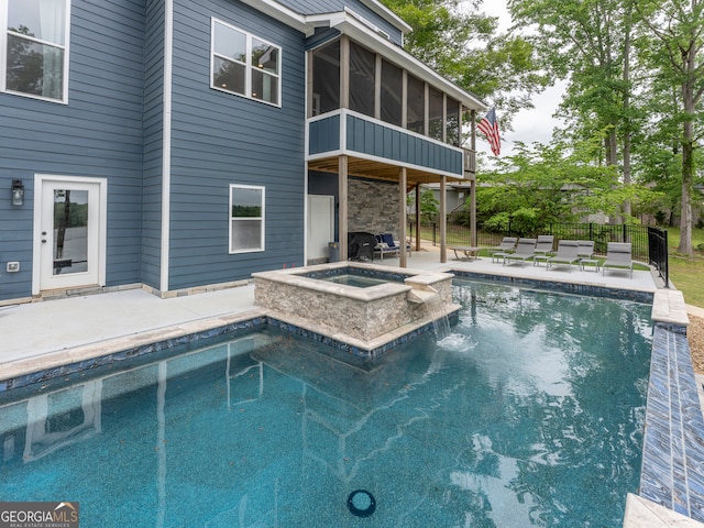 view of pool with a patio area, pool water feature, and an in ground hot tub