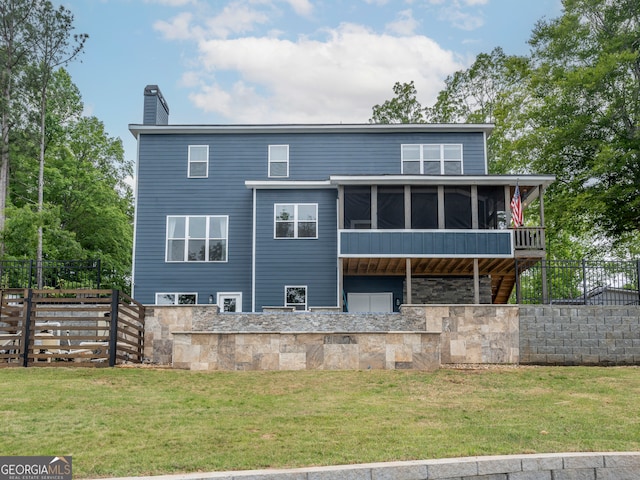 back of house featuring a sunroom and a lawn