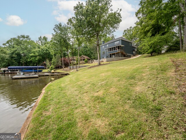 view of yard featuring a water view and a dock