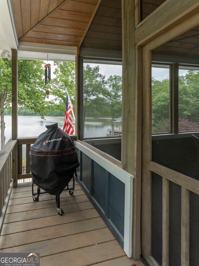 wooden terrace featuring a water view and grilling area