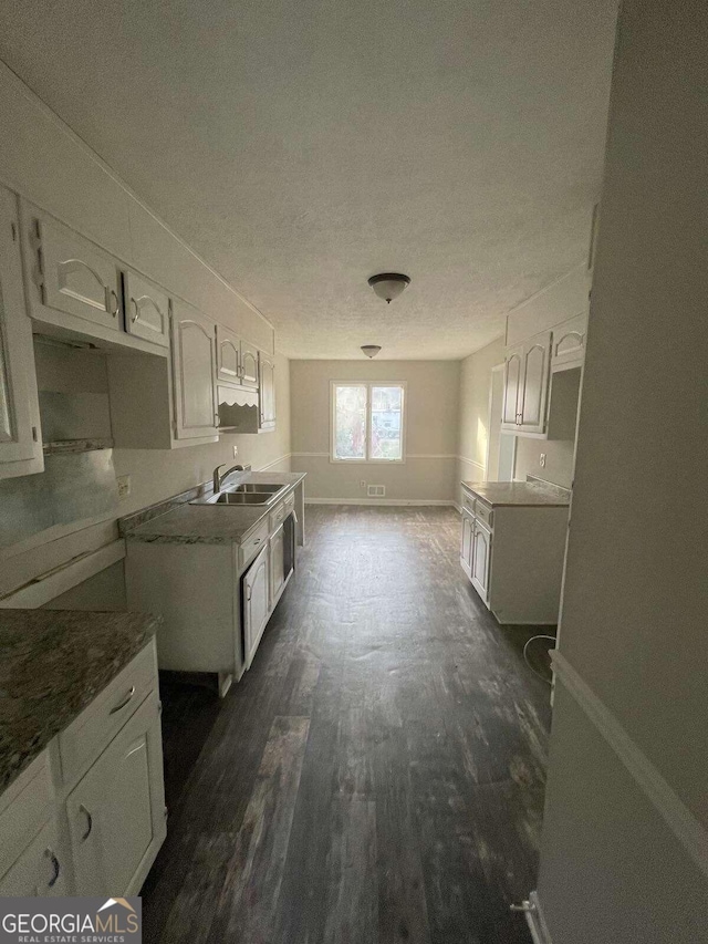 kitchen featuring dark hardwood / wood-style flooring, white cabinetry, sink, and a textured ceiling