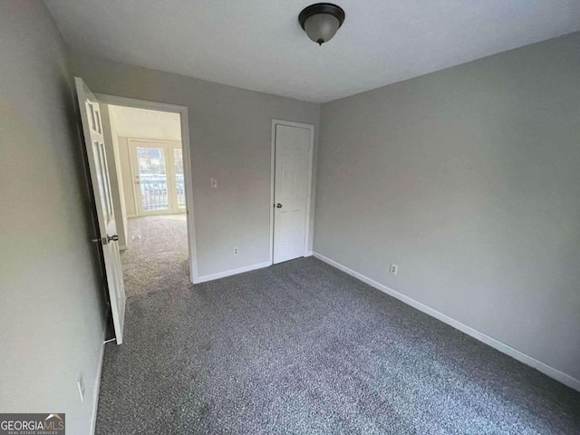 unfurnished bedroom featuring dark carpet