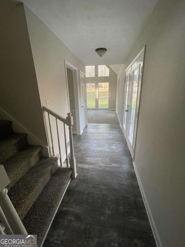 hallway with dark hardwood / wood-style flooring and a textured ceiling