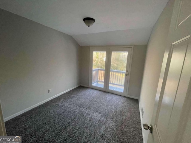 carpeted spare room featuring lofted ceiling