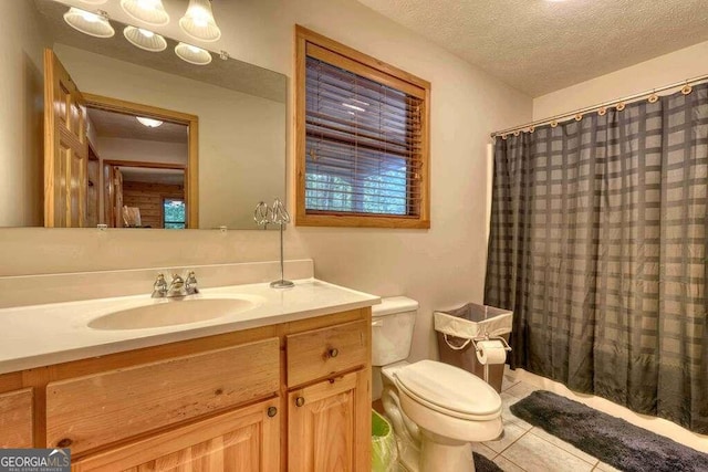 bathroom with a textured ceiling, vanity, tile floors, and toilet