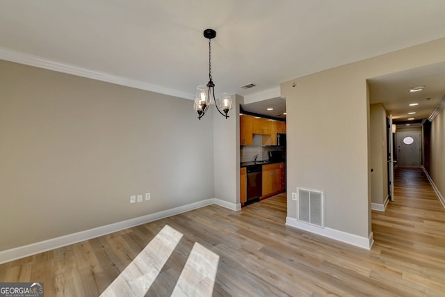 unfurnished dining area with light hardwood / wood-style floors and a notable chandelier